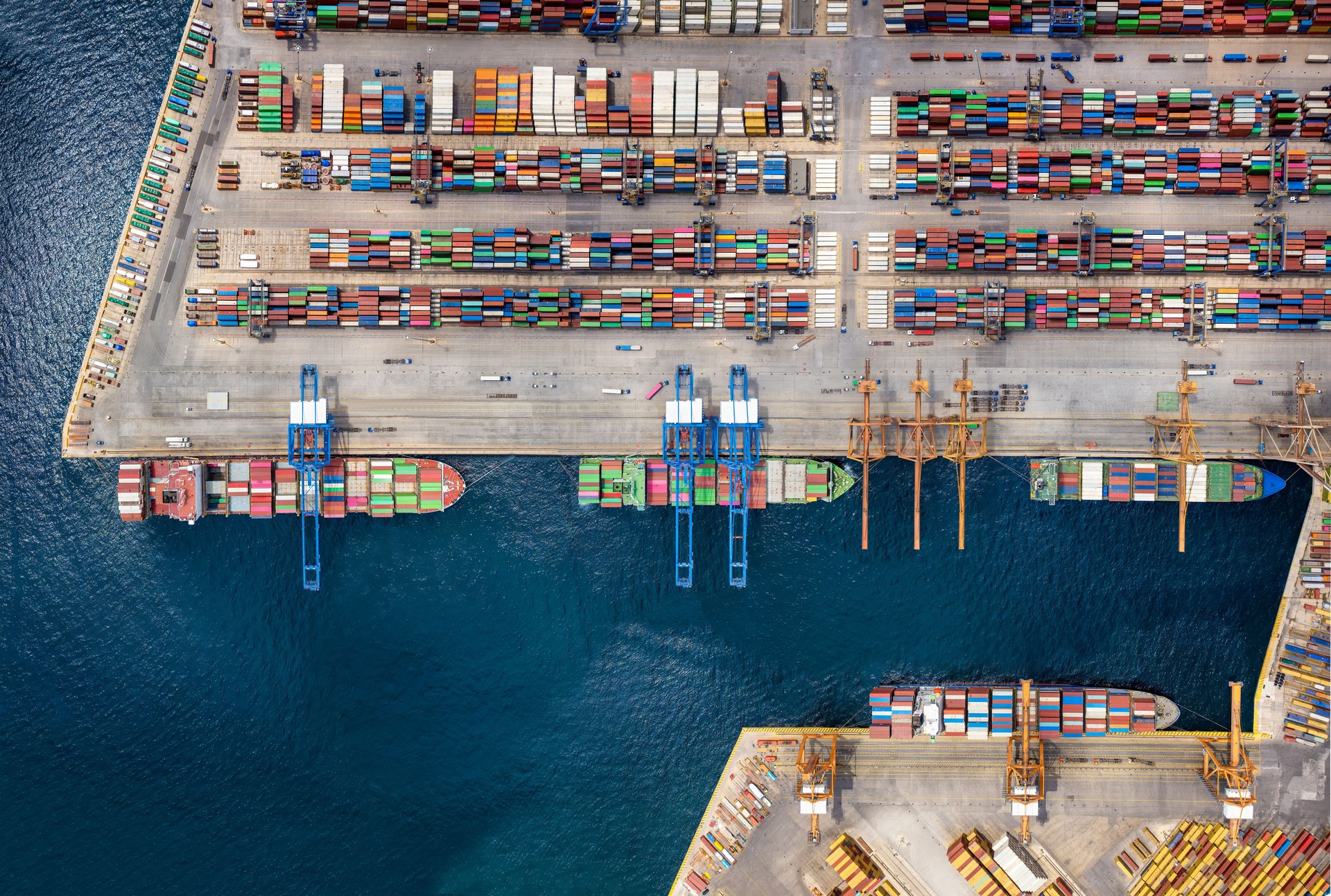 Aerial top down view of a large container cargo ship terminal with industrial vessels