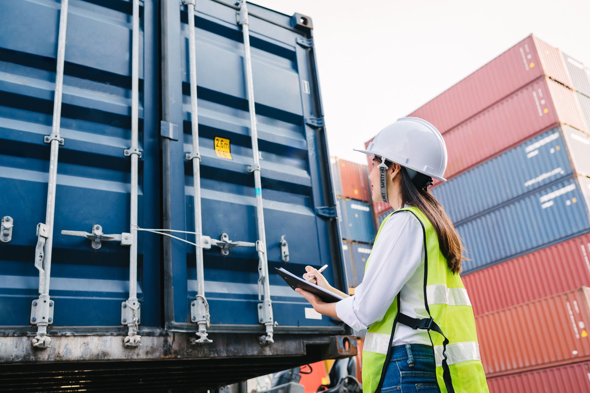 staff woman checking container box for logistic Import Export